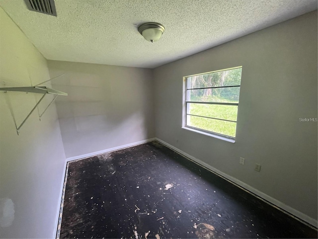 spare room with a textured ceiling