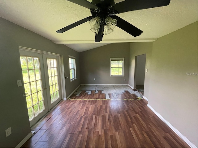 empty room with lofted ceiling, dark hardwood / wood-style floors, and a textured ceiling