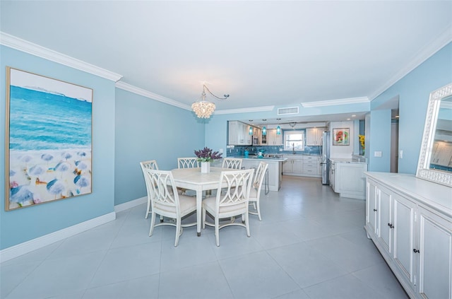 dining area with a chandelier, crown molding, baseboards, and light tile patterned floors