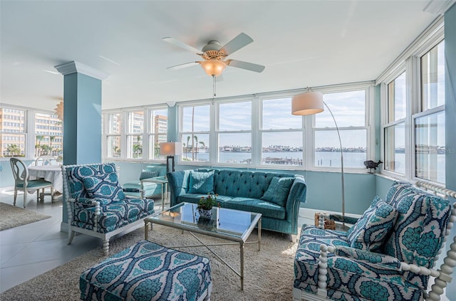 interior space with a ceiling fan and a water view