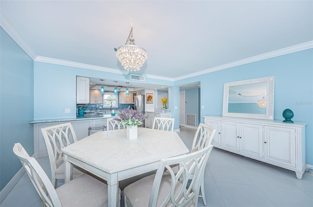 dining space with an inviting chandelier, baseboards, visible vents, and ornamental molding