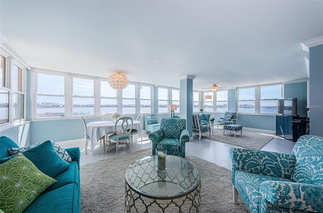 living area featuring ceiling fan, a water view, and tile patterned flooring