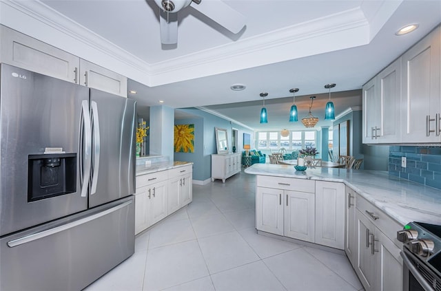 kitchen with crown molding, stainless steel appliances, a raised ceiling, open floor plan, and a peninsula