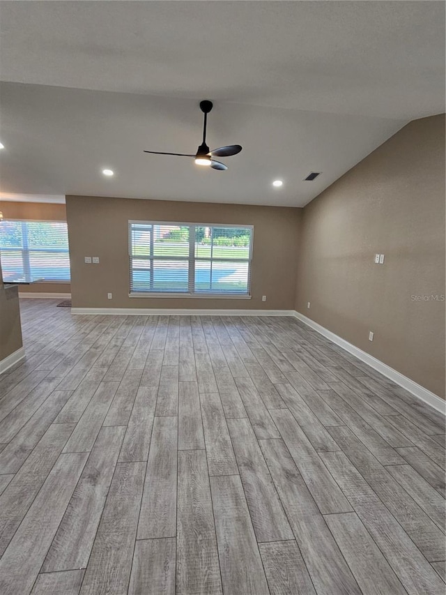 unfurnished room with ceiling fan, vaulted ceiling, and light hardwood / wood-style flooring