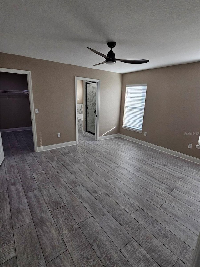 empty room featuring ceiling fan, wood-type flooring, and a textured ceiling