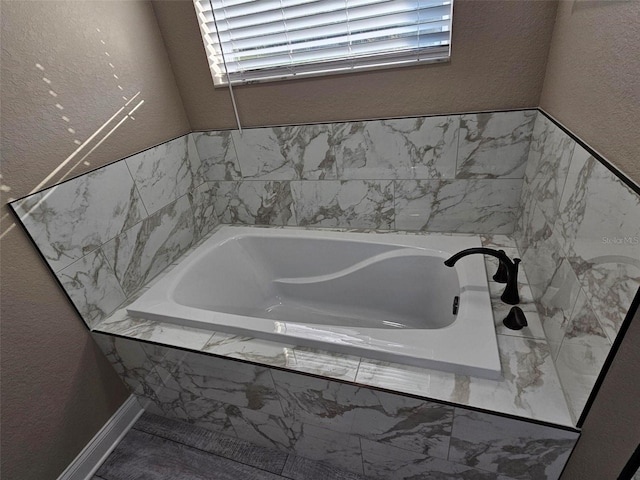 bathroom with a relaxing tiled tub