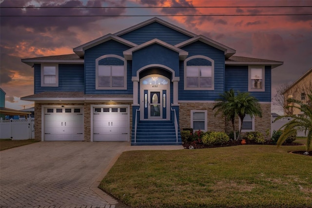 view of front of home with a garage and a lawn