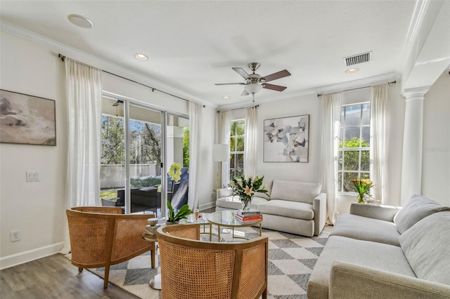 living room featuring ornate columns, ornamental molding, light wood-type flooring, and ceiling fan