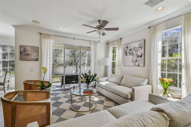 living room with crown molding, plenty of natural light, and ceiling fan