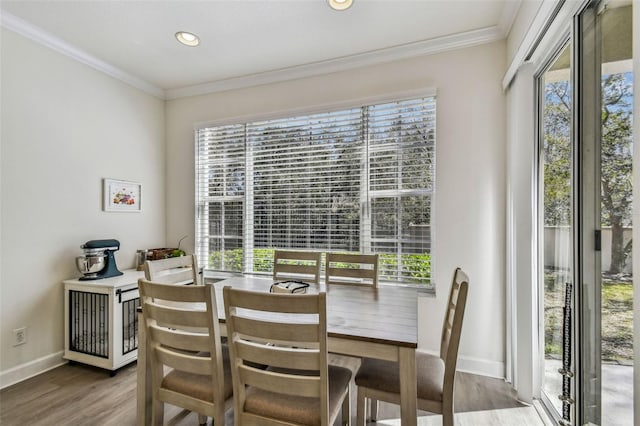 dining space featuring hardwood / wood-style floors and crown molding