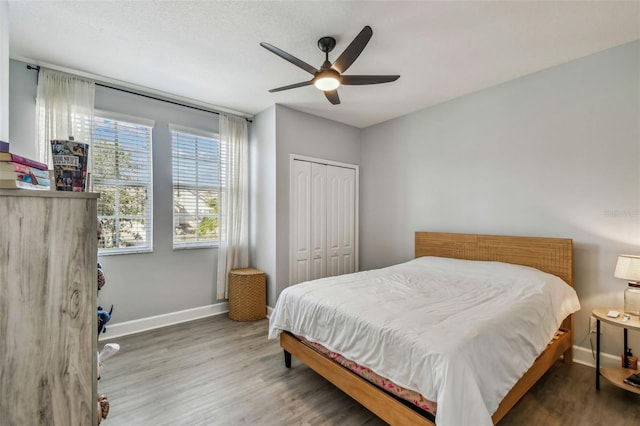 bedroom with wood-type flooring, ceiling fan, and a closet