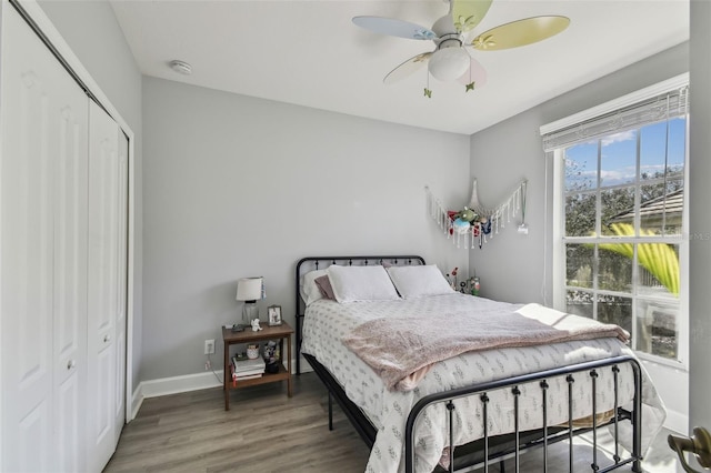 bedroom with dark hardwood / wood-style flooring, a closet, and ceiling fan