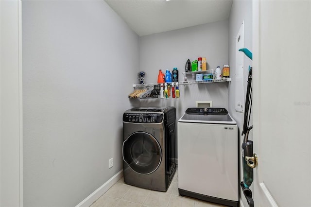 washroom featuring washer and clothes dryer and light tile patterned floors