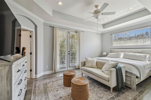 bedroom with french doors, dark hardwood / wood-style floors, access to outside, and a tray ceiling