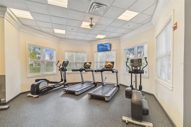 gym featuring plenty of natural light, ornamental molding, and a drop ceiling