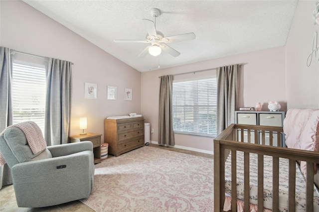 bedroom with ceiling fan, vaulted ceiling, and a textured ceiling