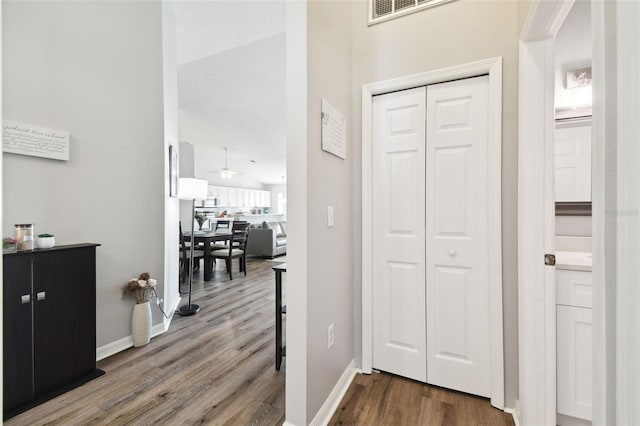 hallway with wood-type flooring and a high ceiling