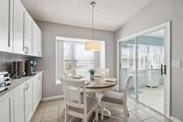 tiled dining room with a textured ceiling