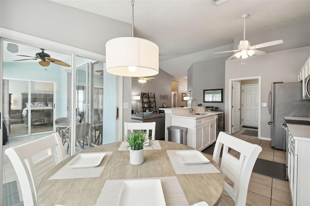 dining room featuring light tile patterned flooring, ceiling fan, lofted ceiling, and sink