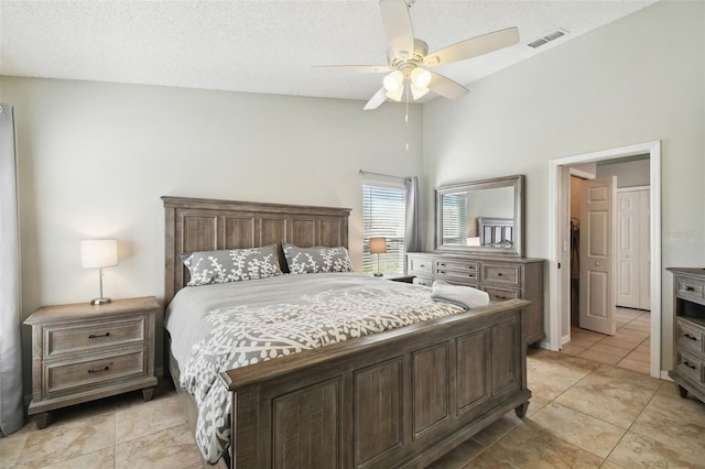 bedroom featuring light tile patterned flooring, ceiling fan, and a textured ceiling