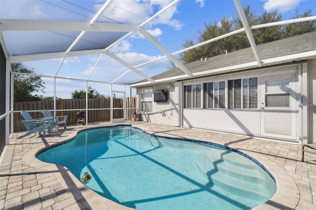 view of swimming pool featuring a lanai and a patio area