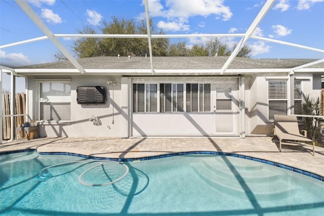 view of swimming pool featuring a patio area and glass enclosure