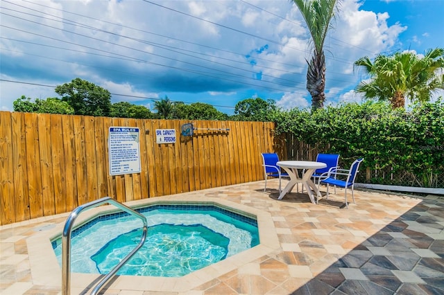 view of pool with a hot tub and a patio