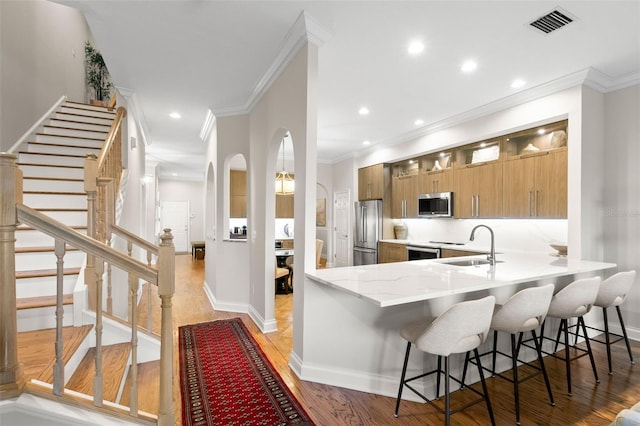 kitchen featuring appliances with stainless steel finishes, a breakfast bar, and kitchen peninsula