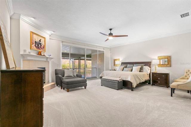 bedroom featuring crown molding, access to outside, light colored carpet, and a tile fireplace