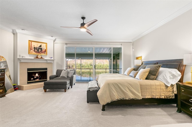 bedroom featuring ceiling fan, carpet flooring, a fireplace, ornamental molding, and access to outside