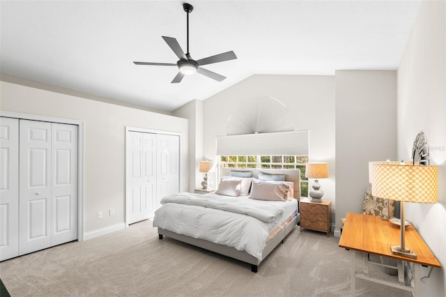 carpeted bedroom with multiple closets, lofted ceiling, and ceiling fan