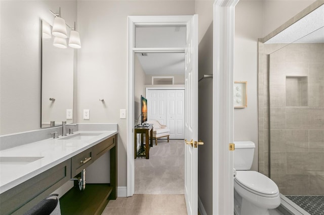 bathroom featuring tiled shower, vanity, and toilet