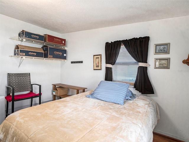 bedroom with hardwood / wood-style flooring and a textured ceiling