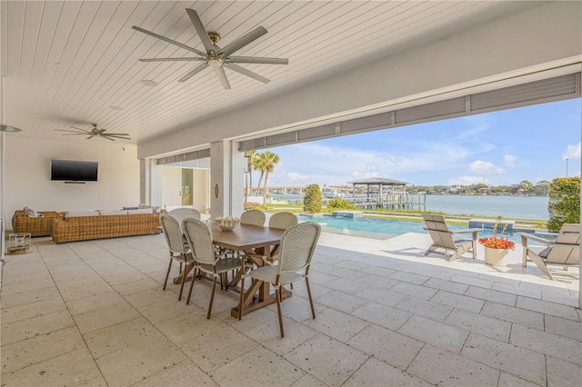 exterior space featuring outdoor lounge area, ceiling fan, and a water view