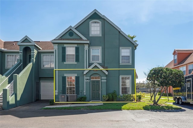 multi unit property featuring an attached garage, driveway, and stucco siding