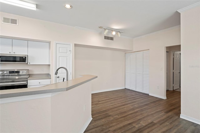 kitchen featuring visible vents, dark wood finished floors, ornamental molding, light countertops, and appliances with stainless steel finishes