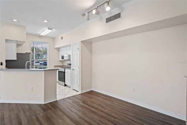 kitchen featuring visible vents, light wood-style flooring, white cabinetry, a peninsula, and appliances with stainless steel finishes