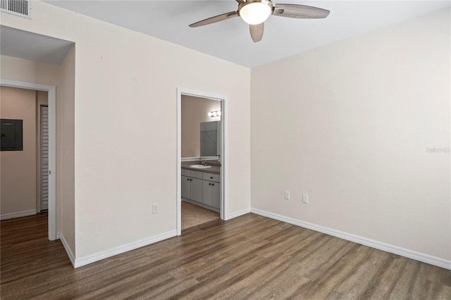 interior space featuring visible vents, electric panel, wood finished floors, baseboards, and ceiling fan