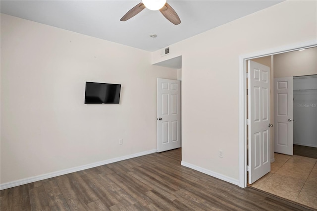 interior space with ceiling fan, wood finished floors, visible vents, and baseboards