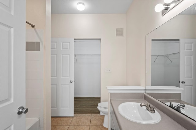 full bathroom with visible vents, toilet, vanity, tile patterned flooring, and a spacious closet