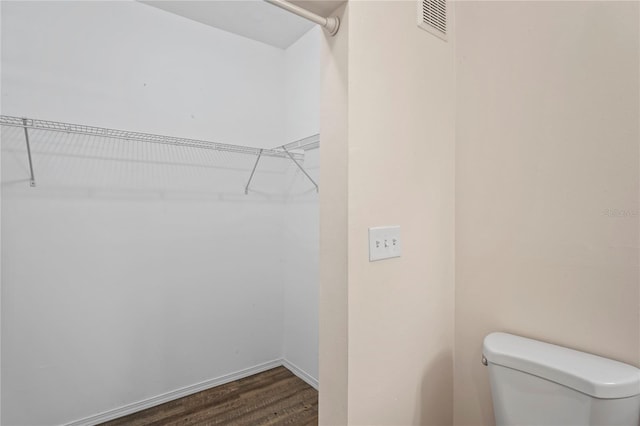 walk in closet featuring visible vents and dark wood-style floors