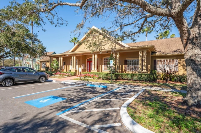 view of front of house featuring stucco siding, uncovered parking, and a porch