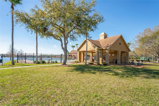 exterior space with a yard, fence, and a water view