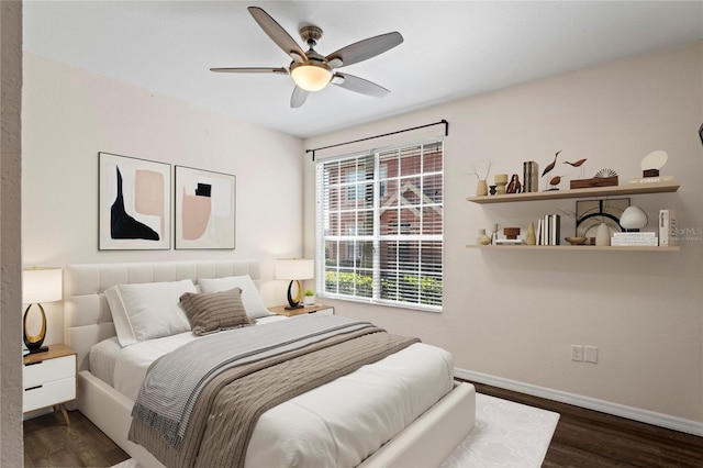 bedroom featuring baseboards, wood finished floors, and a ceiling fan