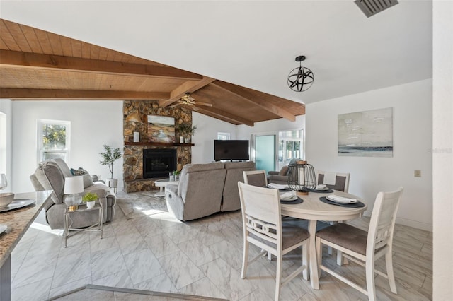 dining space featuring plenty of natural light, vaulted ceiling with beams, wooden ceiling, and a fireplace