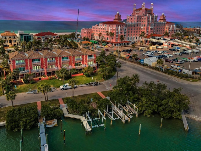 aerial view at dusk featuring a water view