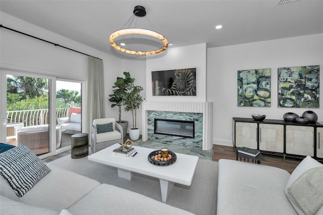 living room featuring a premium fireplace and dark wood-type flooring