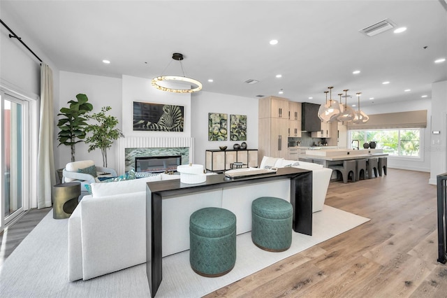 kitchen with pendant lighting, light brown cabinetry, a center island, and light wood-type flooring