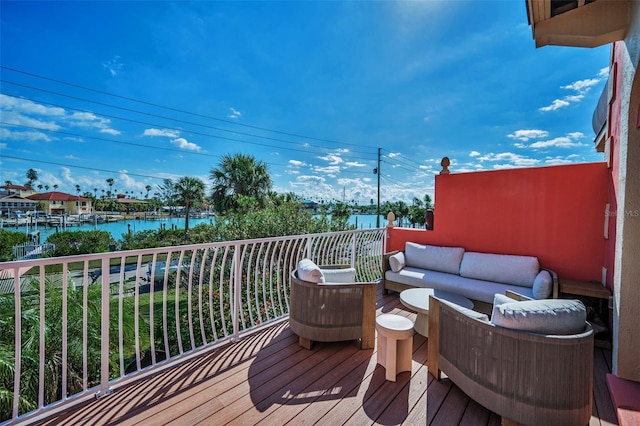 wooden deck featuring an outdoor living space and a water view