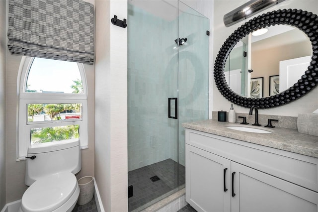 bathroom with vanity, toilet, and a shower with shower door